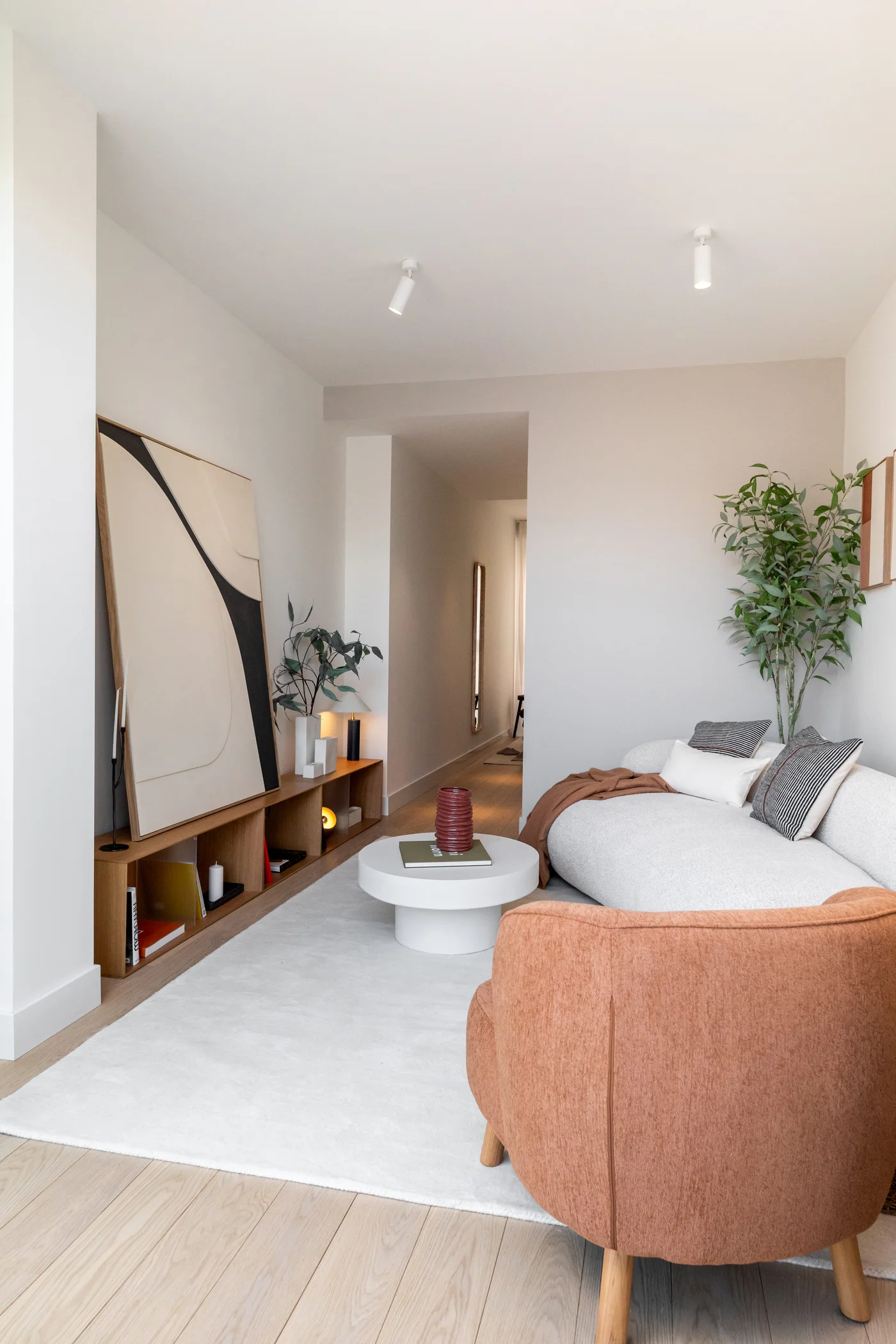 Rincón de lectura con muebles de roble y arte