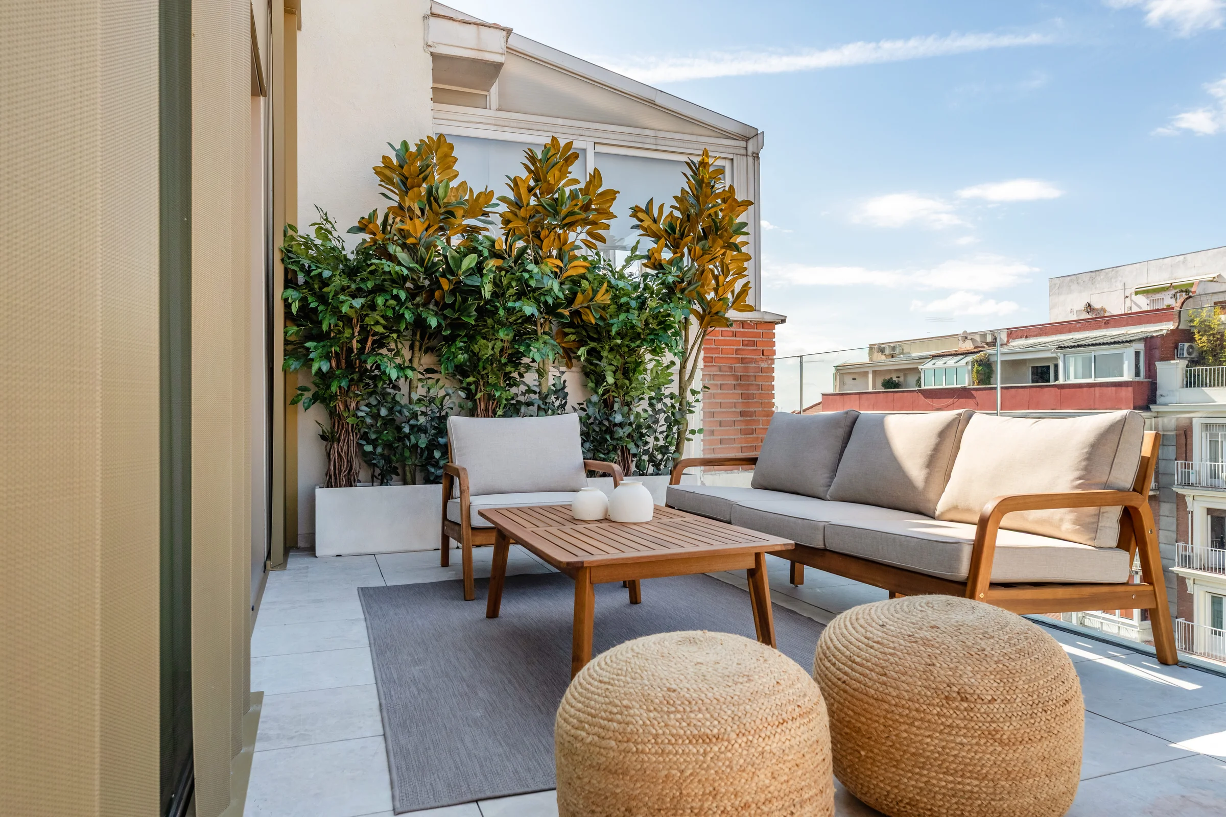 Terraza estar con sofá de madera y magnolios
