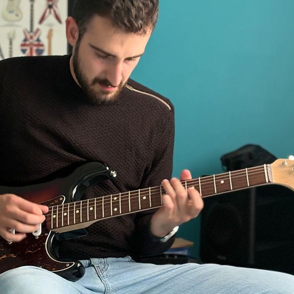 Photo du formateur Hugo Mikikian jouant une stratocaster sunburst.