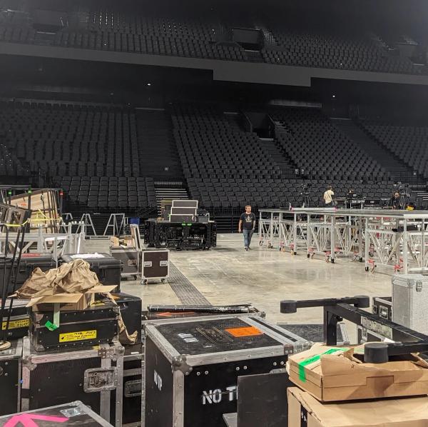 Photo d'une salle de concert vide de public mais rempli de matériel pour monter la scène, les éclairages et les instruments.