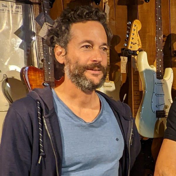 Photo du luthier Nicolas Gréaux dans un magasin de guitares