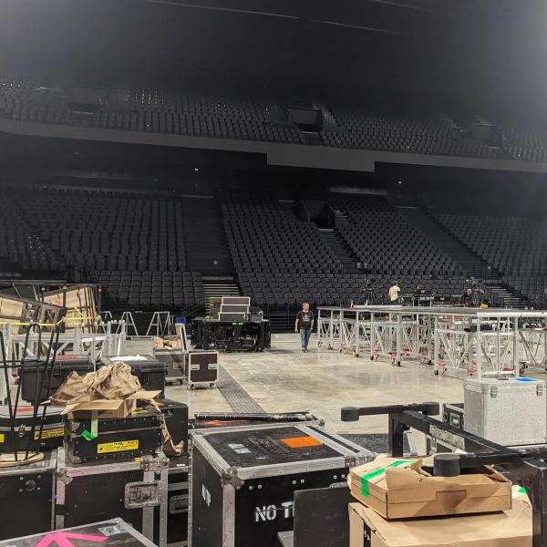 Photo d'une salle de concert vide de public mais rempli de matériel pour monter la scène, les éclairages et les instruments.
