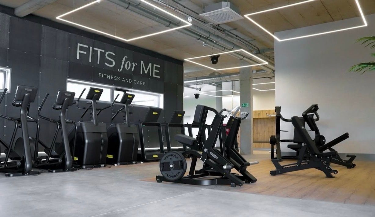 Two people running side by side on treadmills in the FITS for ME studio