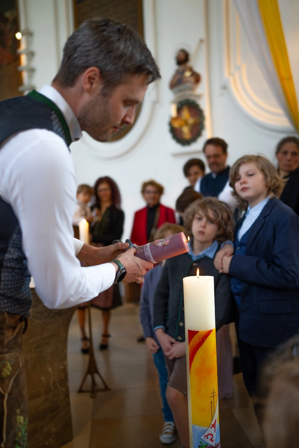 Ein Mann hält eine Kerze während einer Feier in der Kirche.