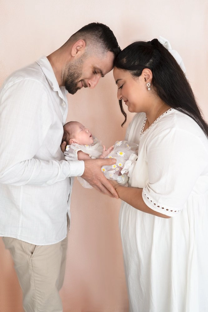 Ein Paar berührt sich an der Stirn und hält sein Baby.