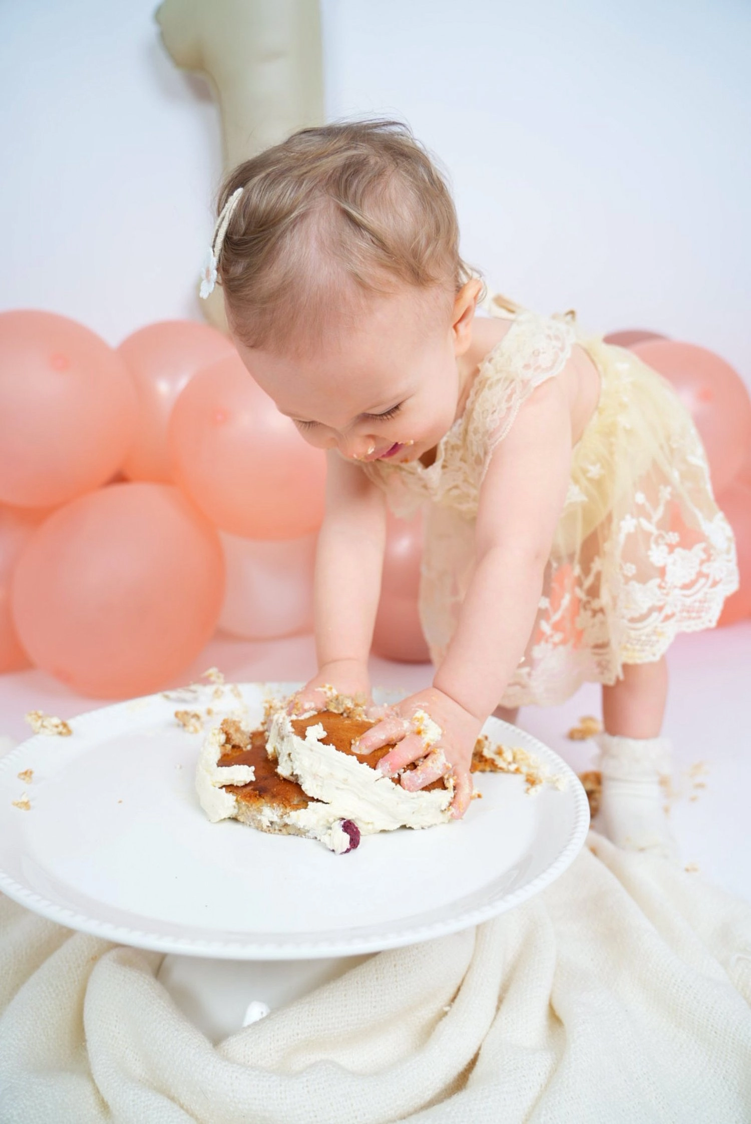 Ein Kind beugt sich mit Tortencreme an den Händen über seine Torte.