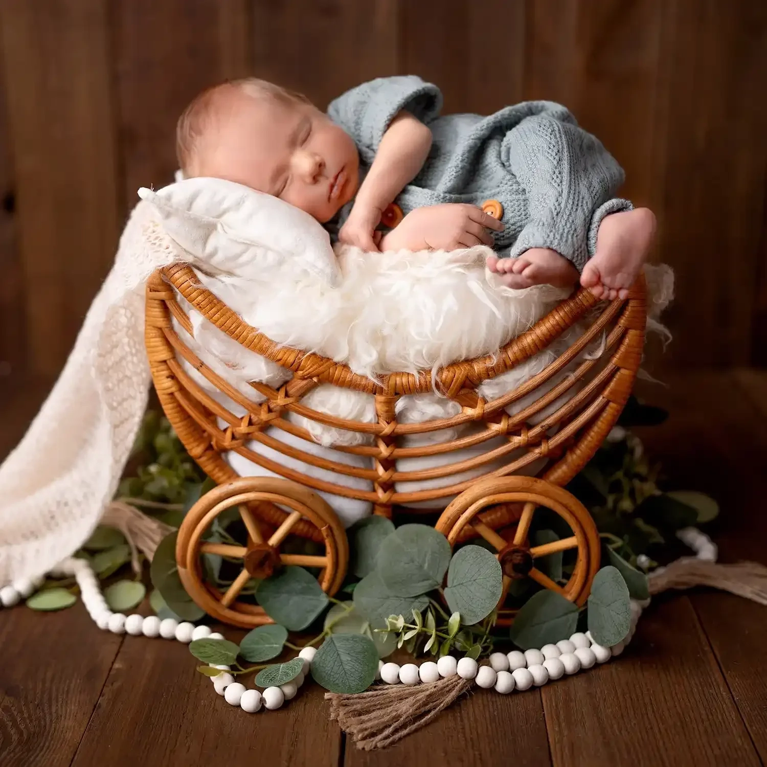 Ein schlafendes Baby liegt im Korbwagen auf weichem weißem Stoff.