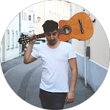 Ein rundes Profilbild zeigt einen Mann mit einer Gitarre über der Schulter.