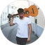 Ein rundes Profilbild zeigt einen Mann mit einer Gitarre über der Schulter.