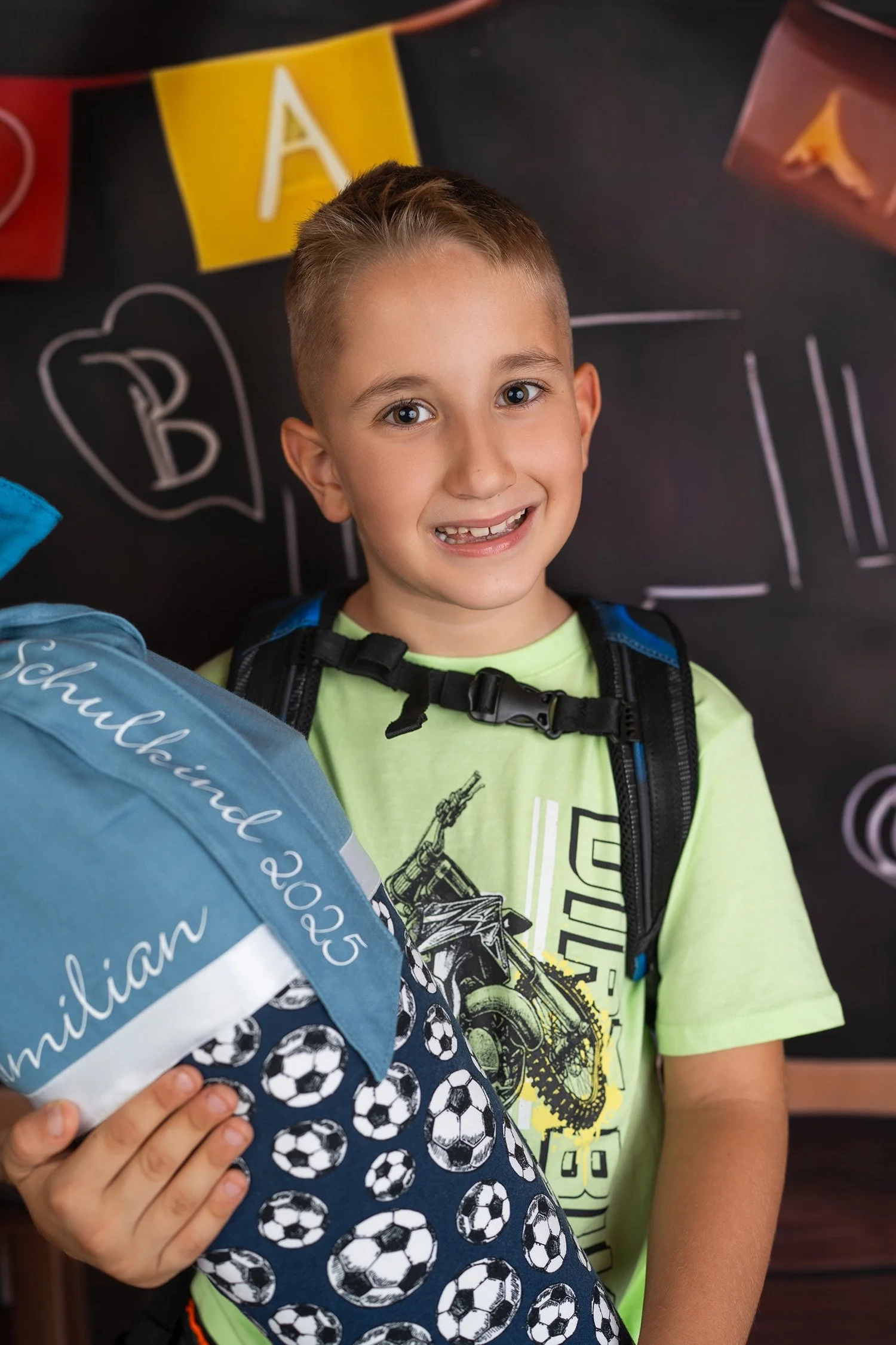 Ein lächelndes Schulkind hält eine blaue Schultüte vor einer Schulkulisse.