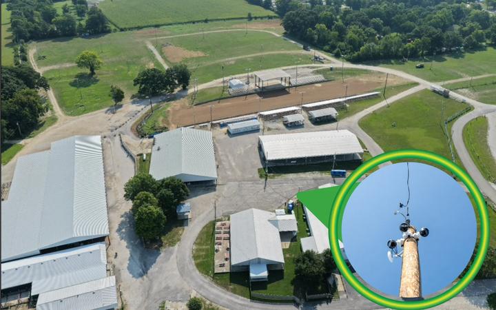 An aerial view of a rural site with a pole-mounted wireless camera picked out in a highlighted circle.