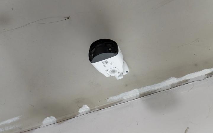An indoor surveillance camera mounted at a ceiling line.