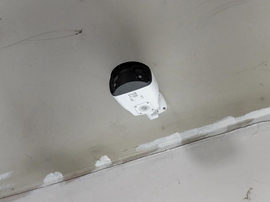 An indoor surveillance camera mounted at a ceiling line.