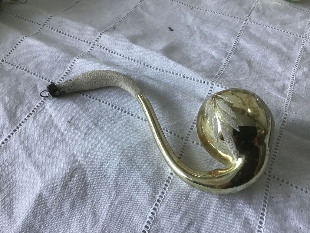 Gouden glazen kerstornament met een gebogen hals en een bol