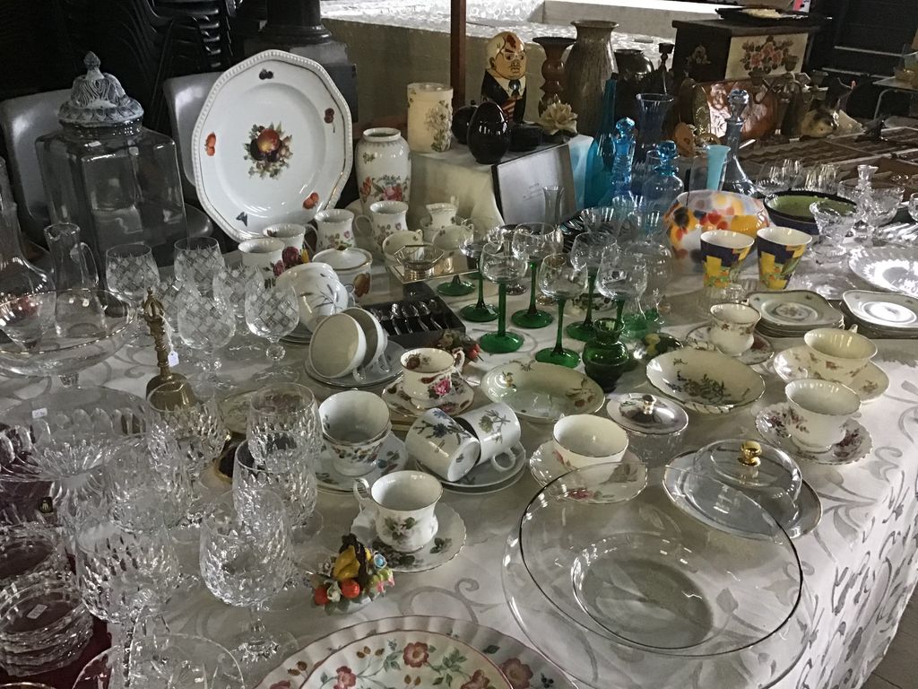 Tafel met kristallen glazen, groene wijnglazen en kopjes met bloemenmotief