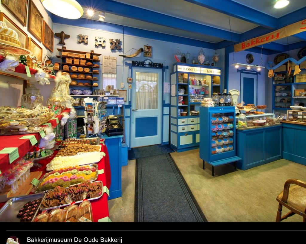 Winkel van Bakkerijmuseum De Oude Bakkerij met blauwe kasten en een toonbank vol koek en snoep
