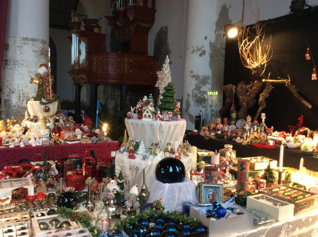 Kraam met kerstdorpjes, kerstballen en kaarsen voor een zwarte achtergrond