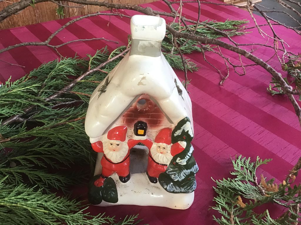 Wit keramisch huisje met twee kerstmannen bij de deur
