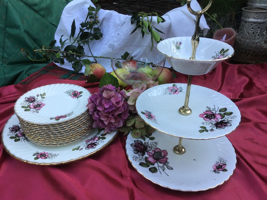 Two-tier cake stand and plates with a rose pattern on a red cloth
