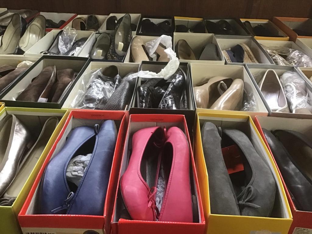 Open schoenendozen vol damesschoenen in zwart, blauw en roze
