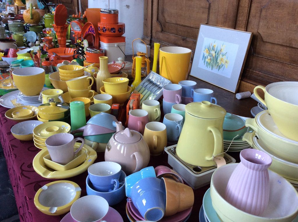 Pastelkleurig servies in geel, blauw en roze: kopjes, theepotten en schaaltjes