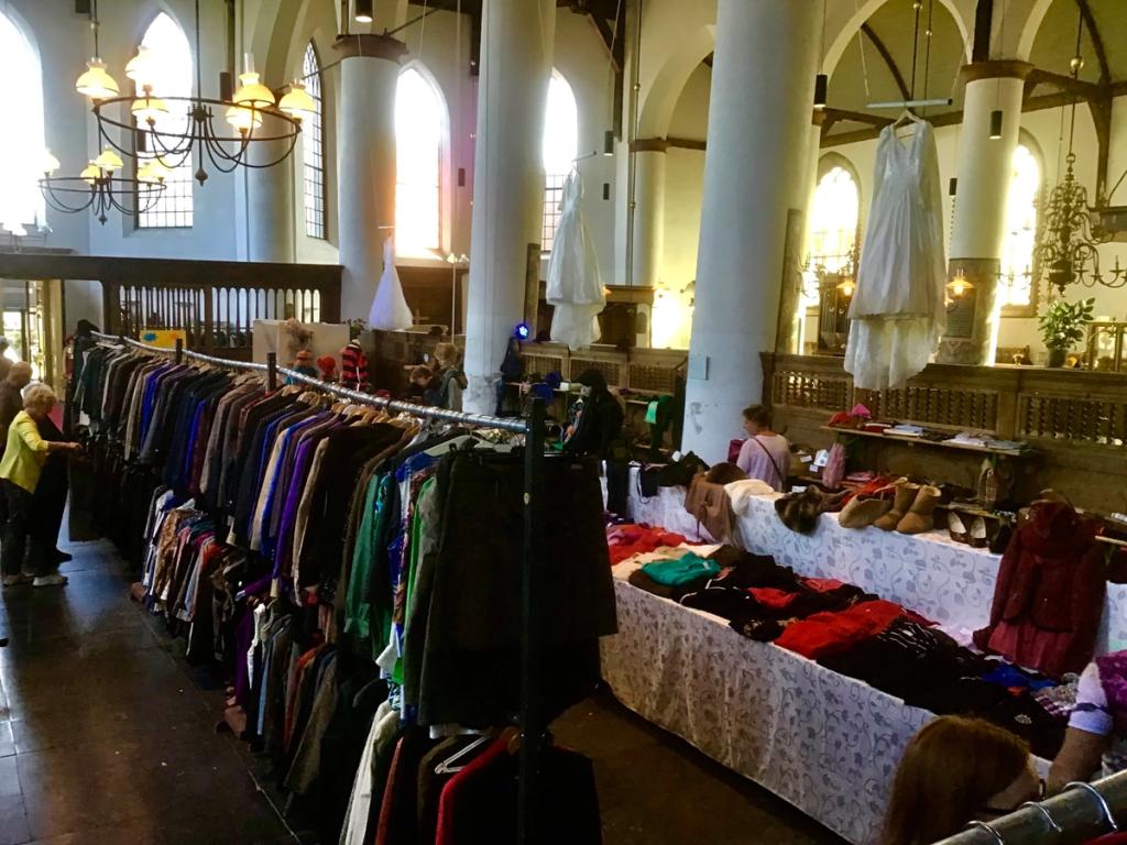 Kledingrek en een jurk aan een pilaar in de lichte kerk