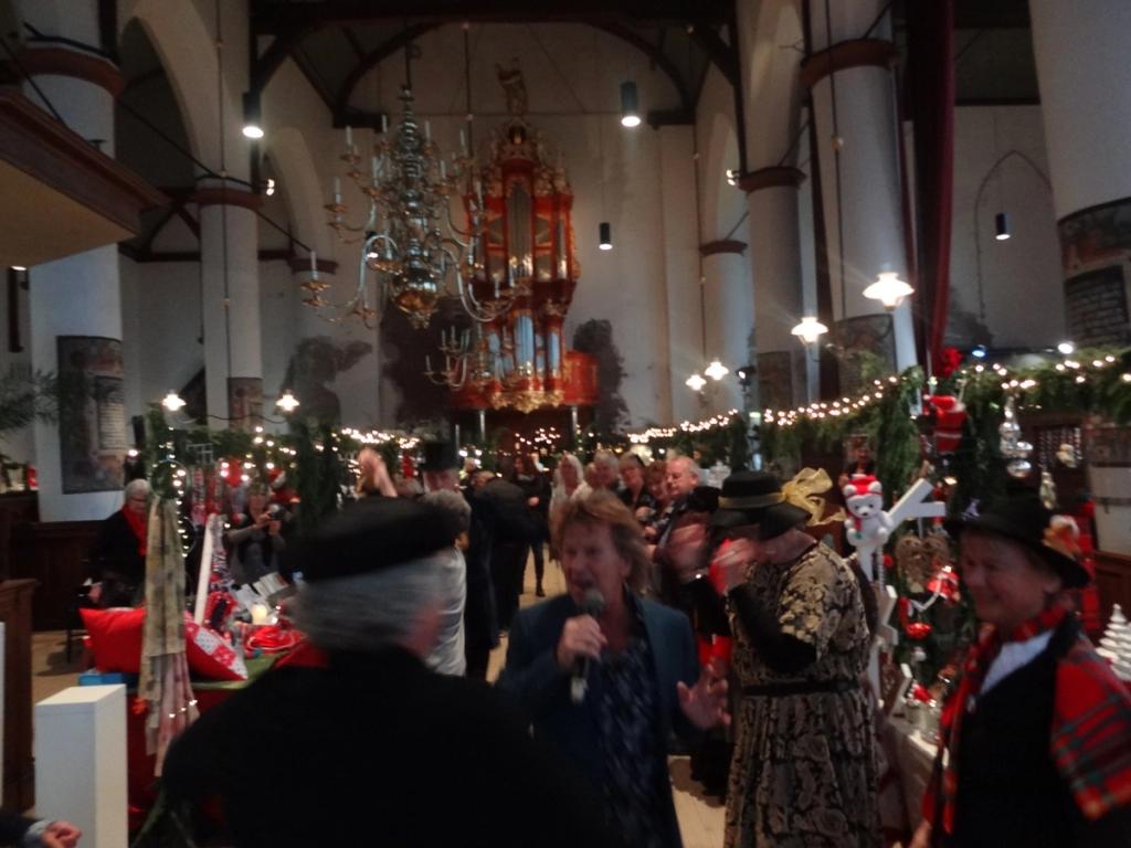Zangers en Dickens-figuren in het middenschip van de kerk