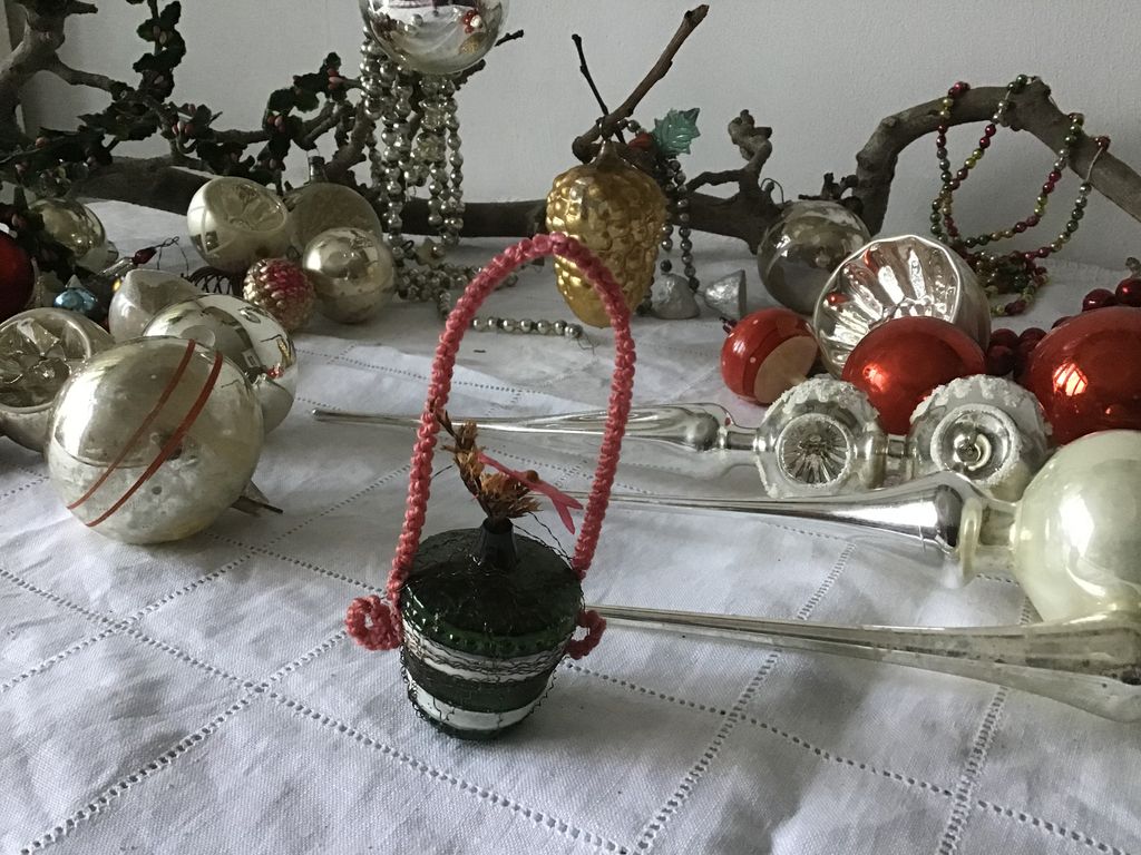 Silver Christmas baubles, glass tree toppers, bead garlands and a red basket