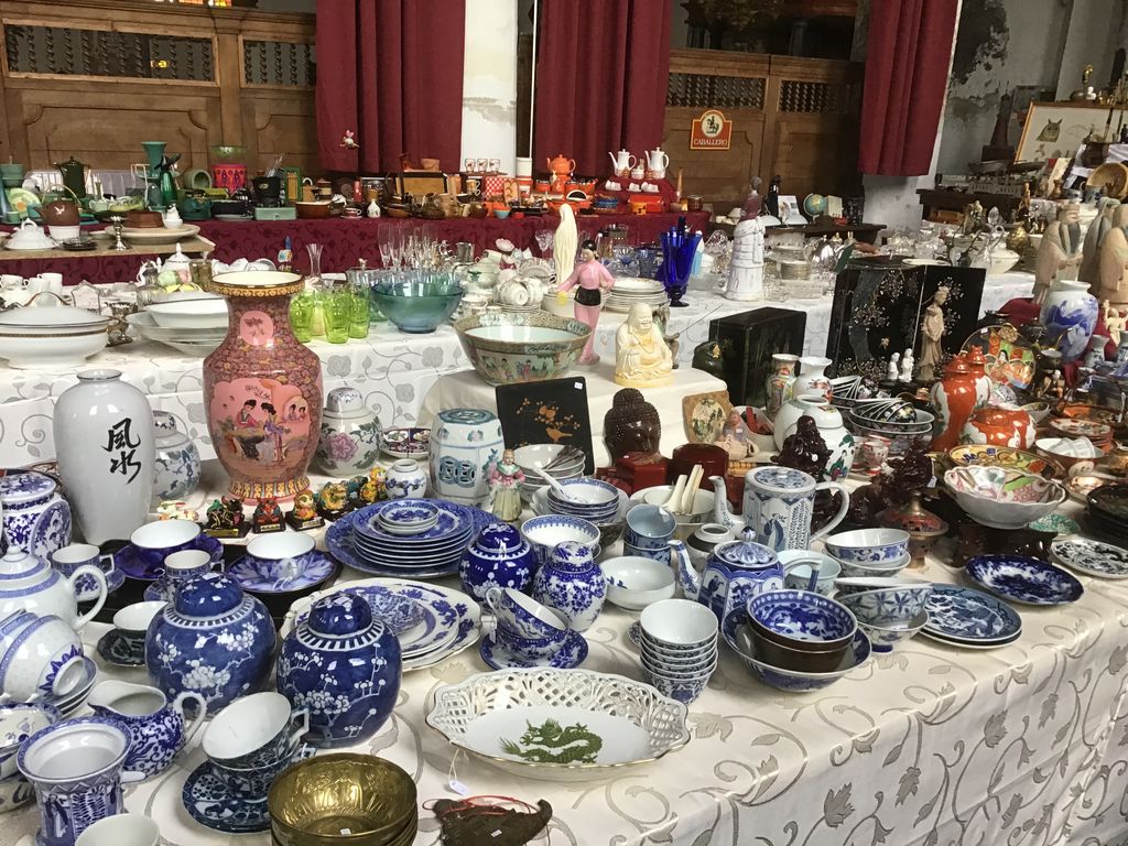 Table full of blue and white pottery, Chinese vases and Asian figurines in the church