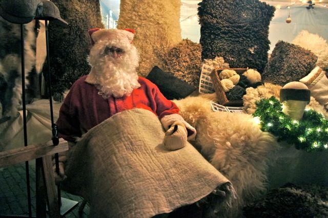 Kerstmanfiguur met deken tussen schapenvachten en wol