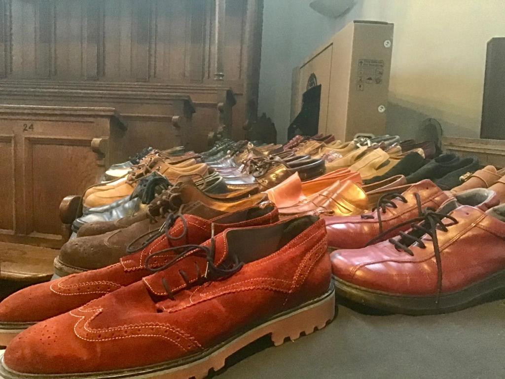 Rij bruine en oranje herenschoenen op een tafel