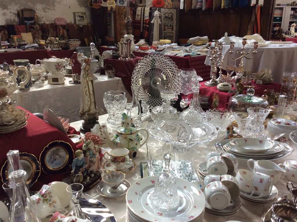 Kristallen schalen en glazen, kandelaars en servies met roosjesmotief op een lange tafel