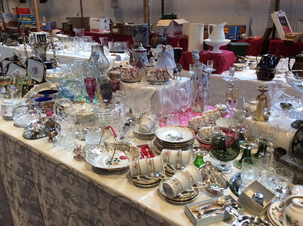 Marktkraam met tafel vol kristal, glaswerk, kopjes en zilverwerk