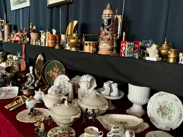 Lange tafel in de kerk met zwart servies, kristallen schalen, gekleurde borden en een silhouetportret