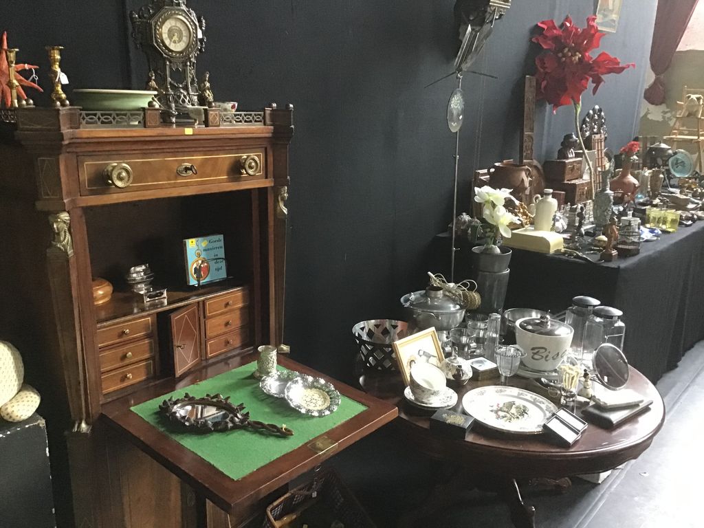 Antique wooden writing desk with small objects, a small mirror and pewter on tables