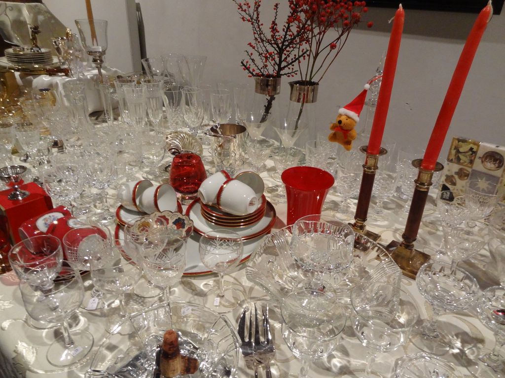 Tafel met kristallen glazen, kopjes en twee rode kaarsen
