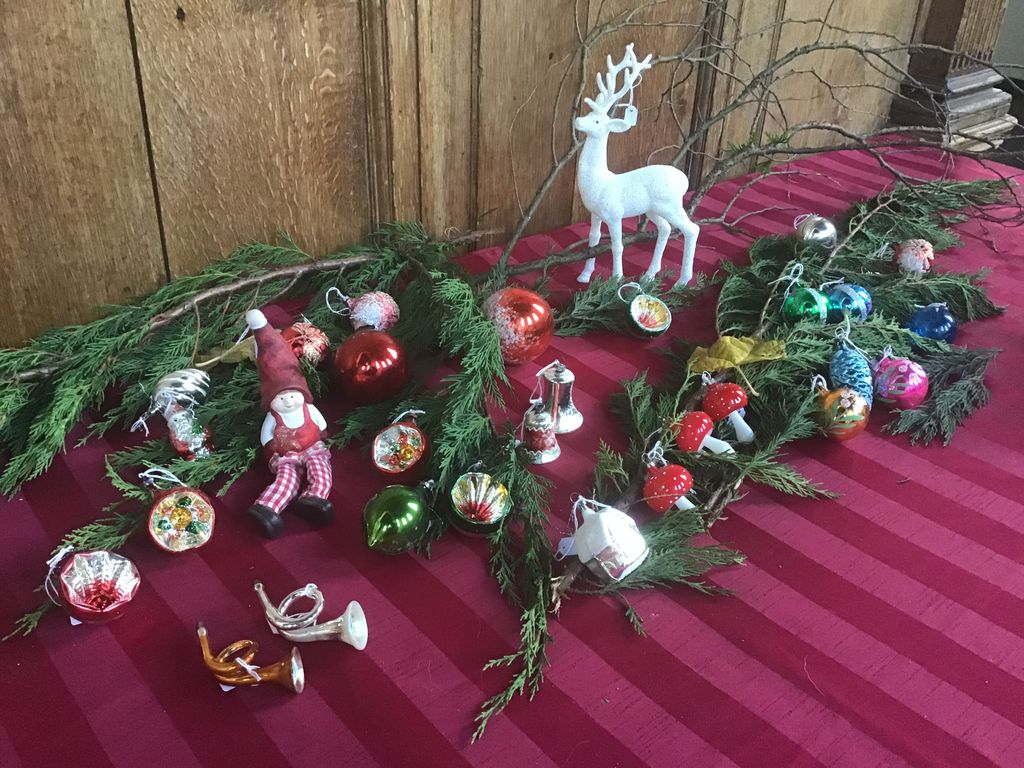 Kleine kerstballen, een kabouter, hoorntjes en een wit hertje op dennentakken