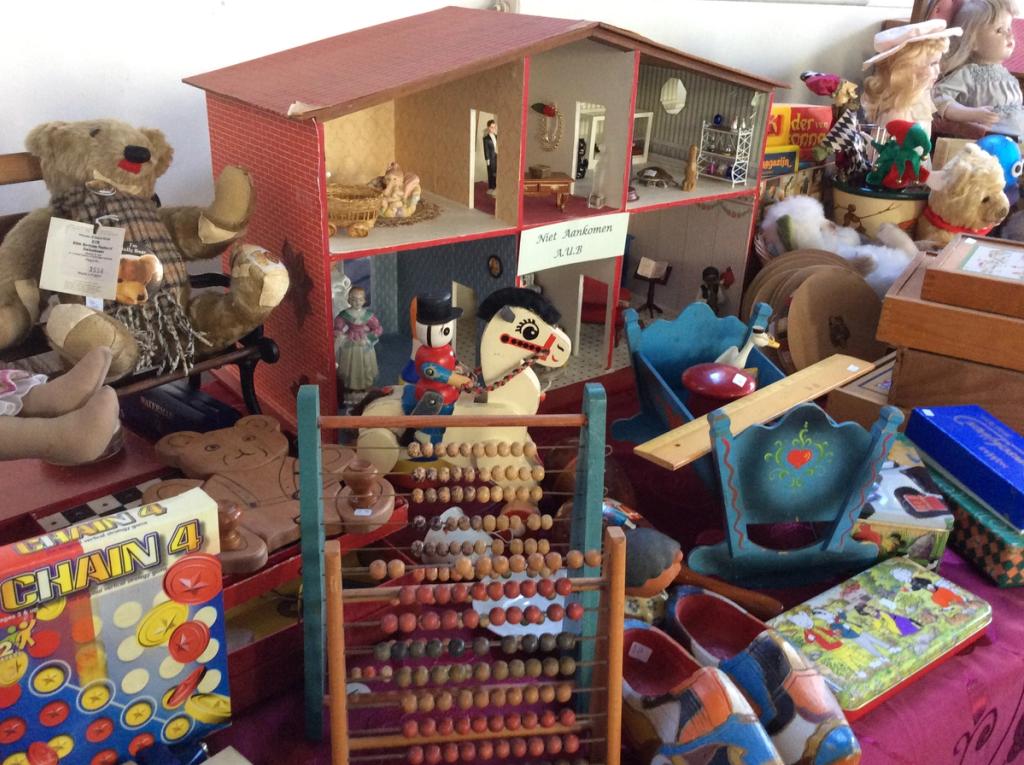 Doll's house, wooden abacus, teddy bears and old toys on a table