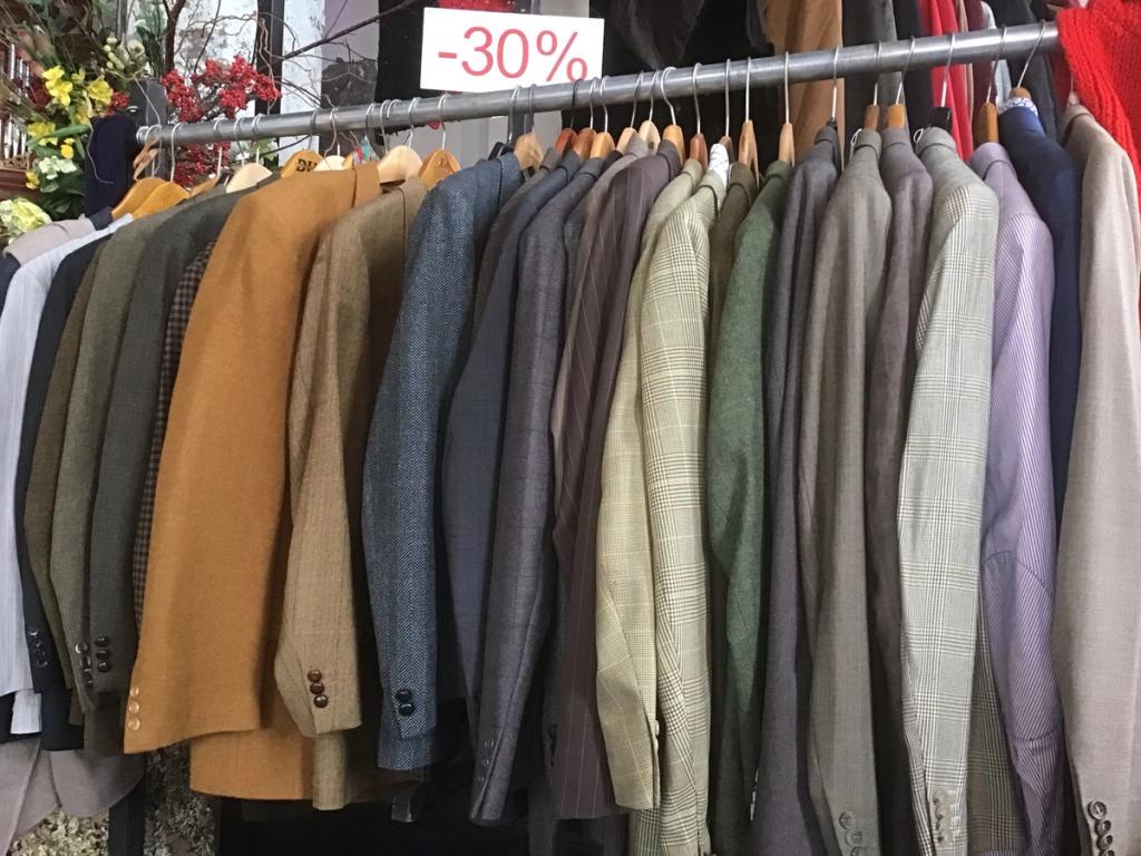 Rek met colberts en jasjes in bruin en grijs, met een bordje "-30%"