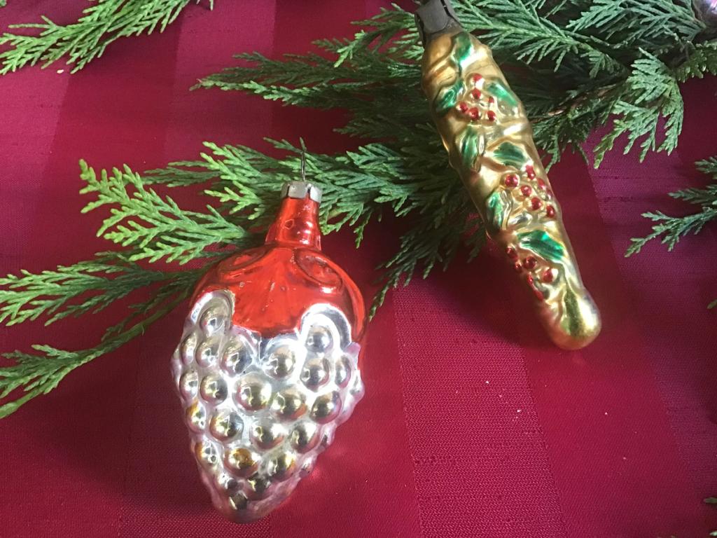 Glass bunch of grapes and gold icicle with berries on a red cloth
