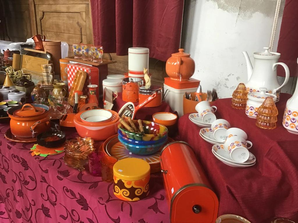 Orange retro kitchenware, pans and cups on a table