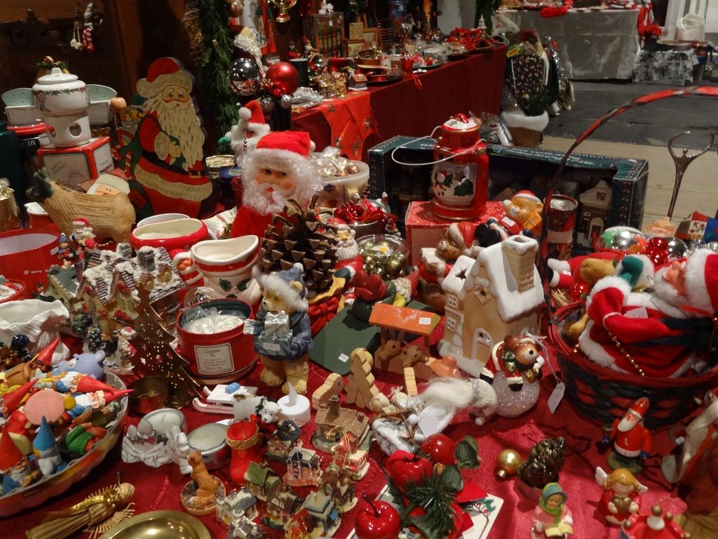Stall full of small Father Christmas figures, Christmas villages and red Christmas decorations