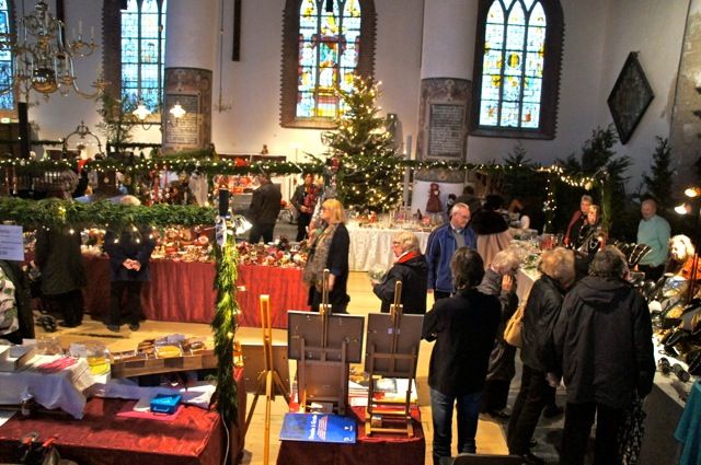 Overzicht van de kerk met kramen, bezoekers en een kerstboom