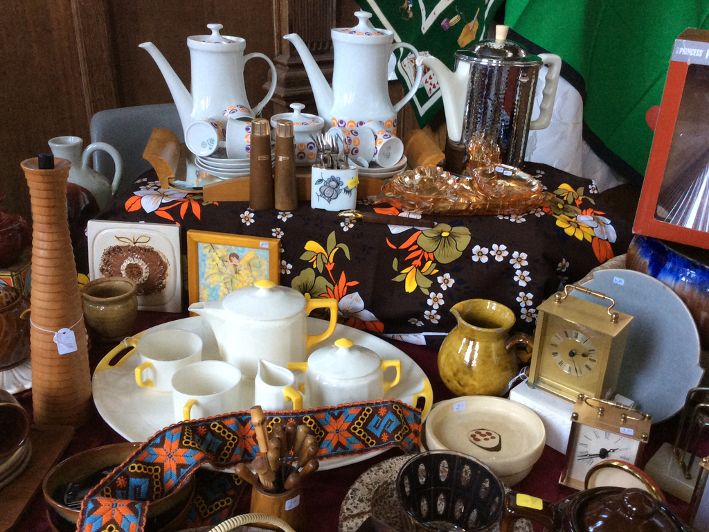 Retro koffie- en theeservies, vaasjes, een kleine klok en een geborduurd lint