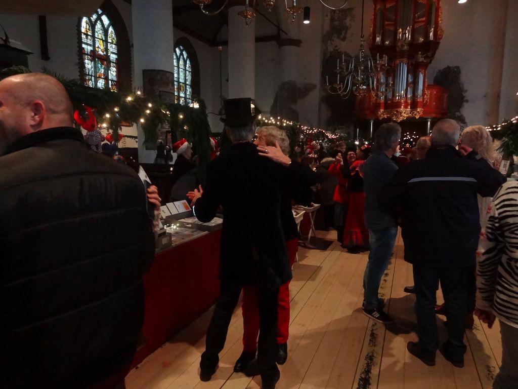 Dansend paar in Dickens-kleding tussen bezoekers in de kerk