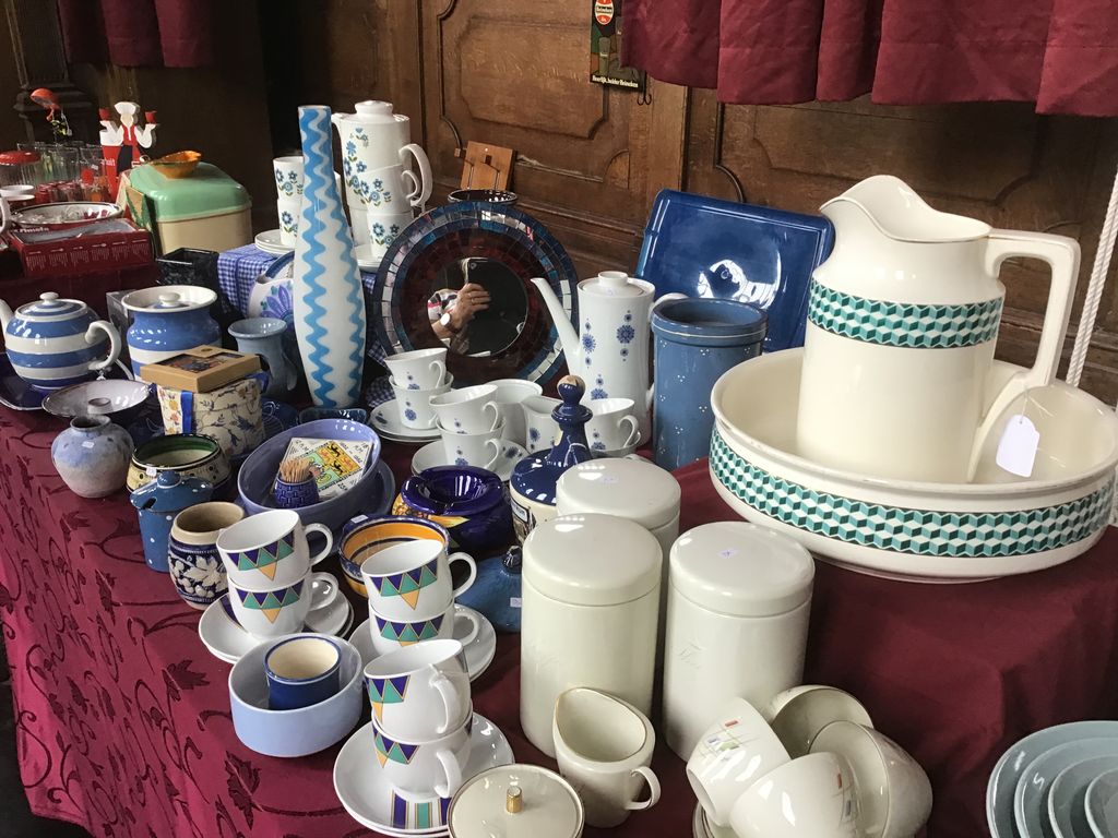 Blue and white pottery, coffee cups and a white jug with bowl on a table with a red cloth