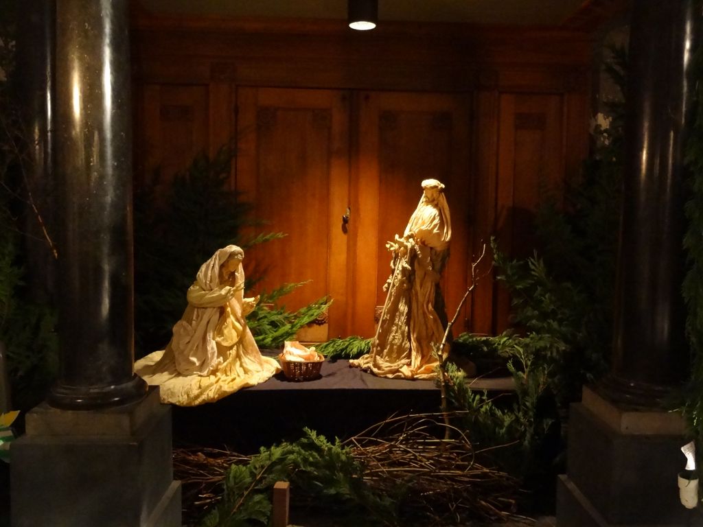 Kerststal met twee gouden figuren tussen dennentakken