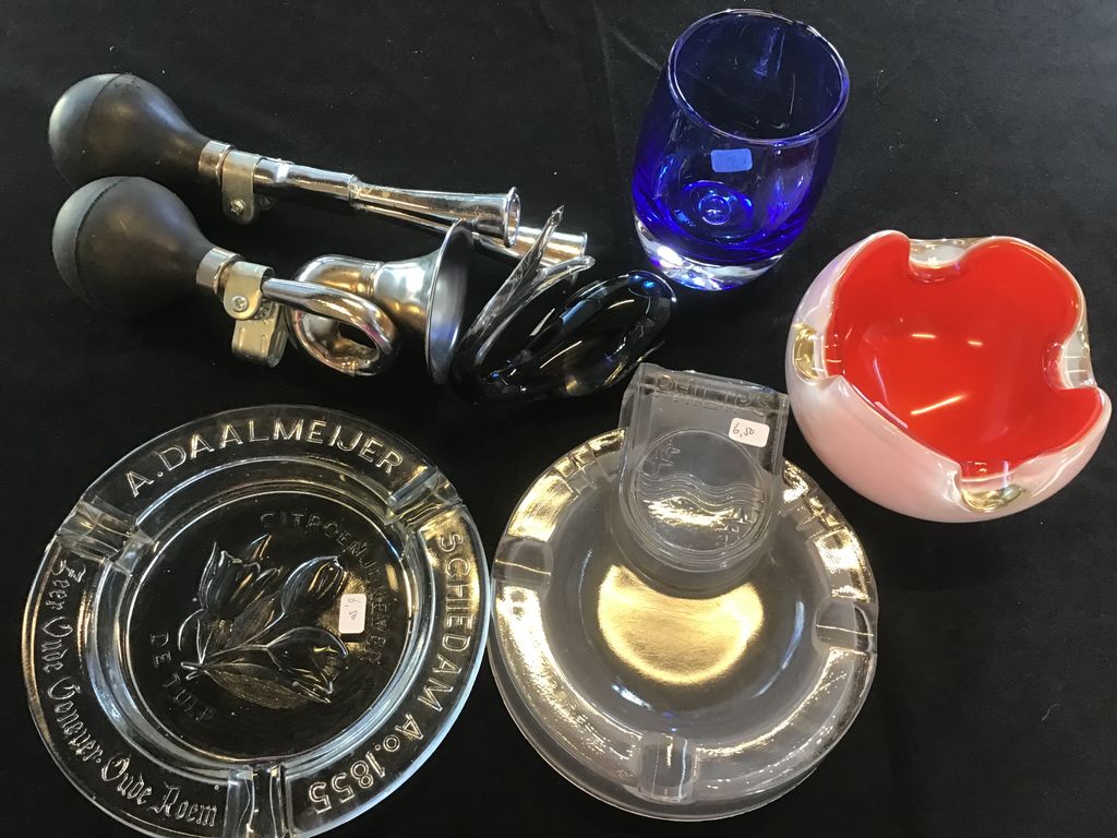 Claxons, glazen asbakken, een blauw glas en een rood met wit glazen schaaltje