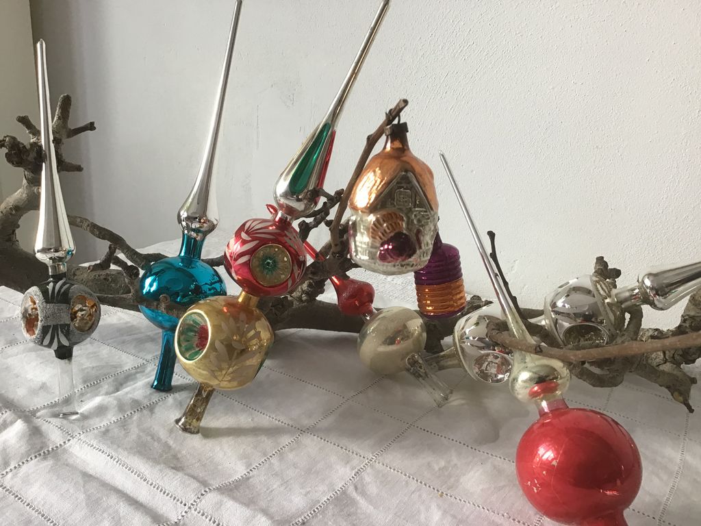 Antieke glazen kerstpieken en kleurige kerstballen op een tak