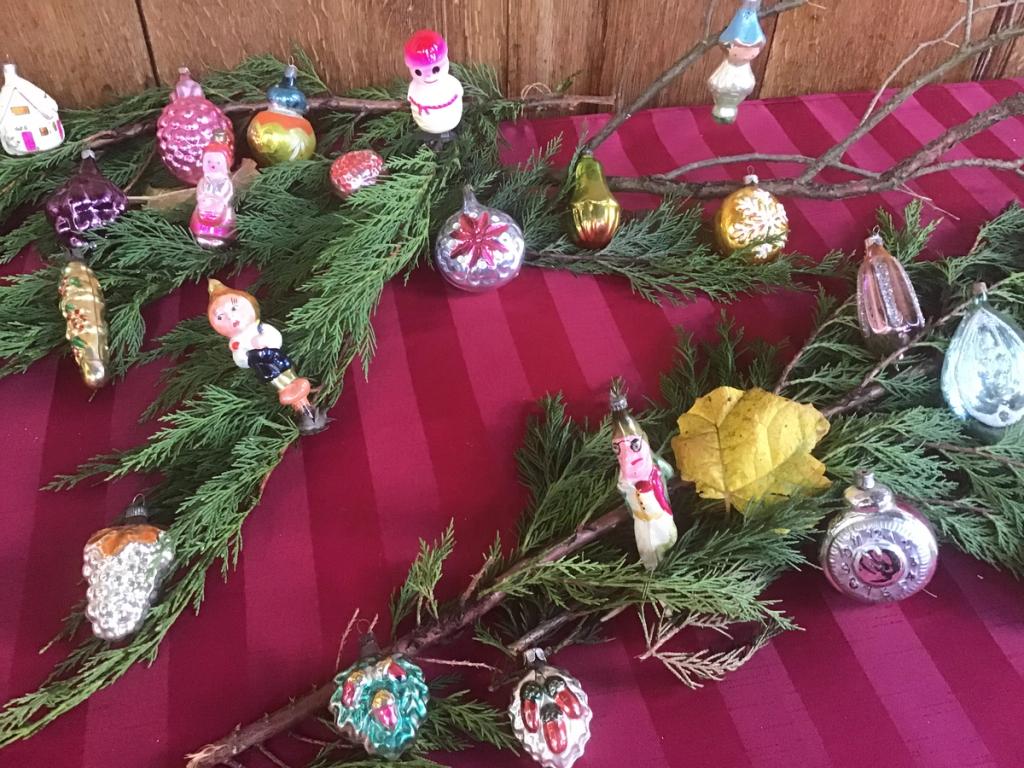 Veel kleine antieke glazen hangers, vruchten en figuurtjes op dennentakken